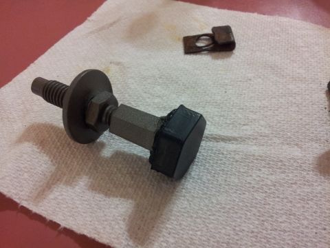 1976 Ford Ranchero - A disassembled automotive part, possibly a bolt and clip, lies on a white cloth surface.
