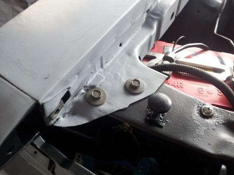 1976 Ford Ranchero - Close-up view of an engine bay, showing a red battery and various metal brackets and bolts. The Supermotors.net logo is visible at the bott…