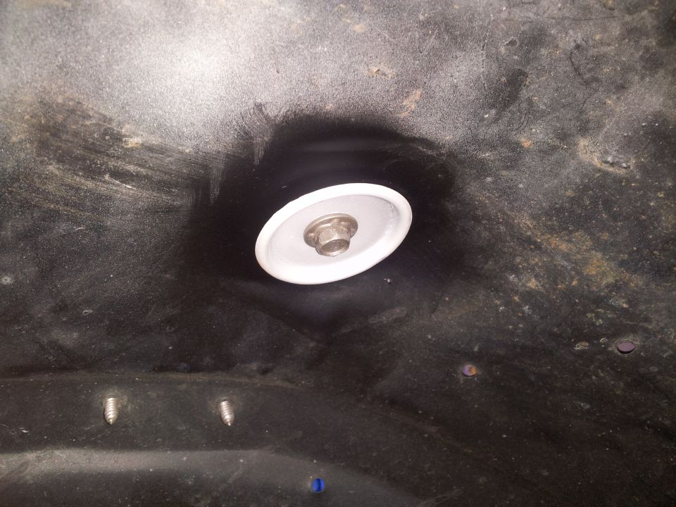 Underside view of a vehicle part with a bolt and washer assembly