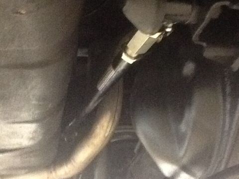 1967 Ford Galaxie - A close-up view of a vehicle's suspension system, showing a metal rod and fitting.