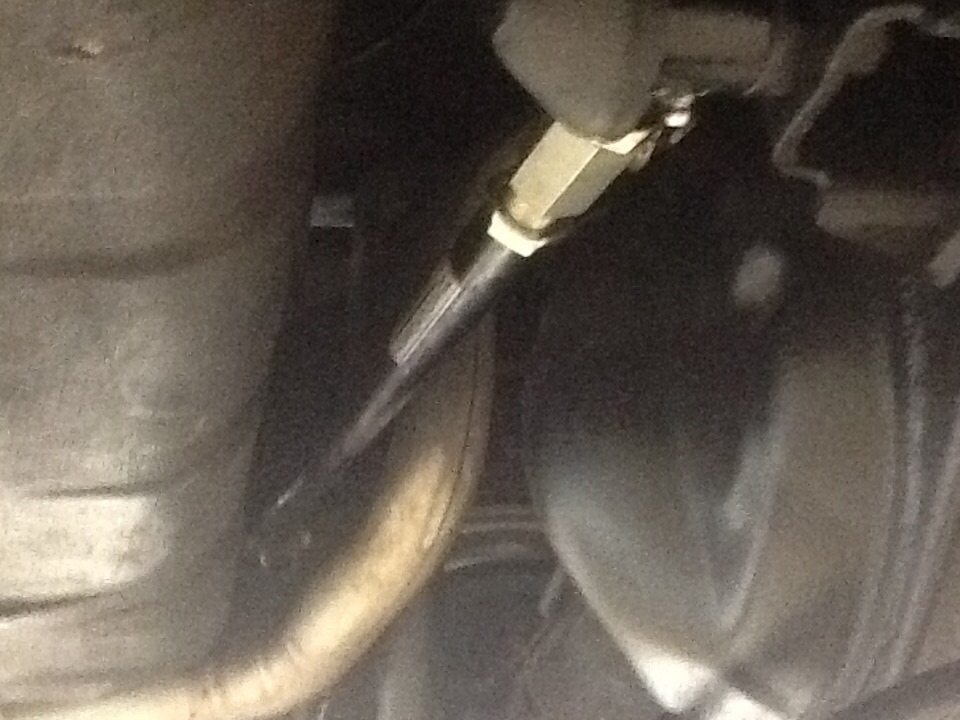 Dark underbody detail of threaded adjuster on a link bar between fuel tank and rear axle