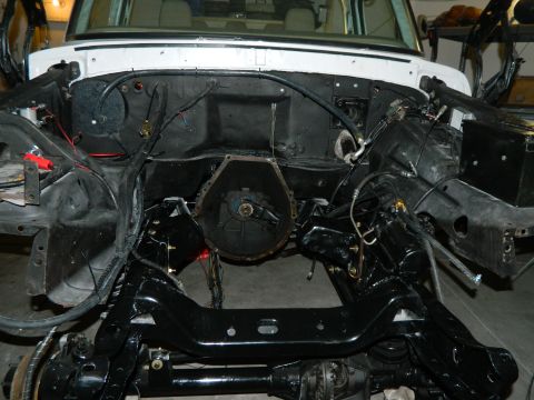 1979 Ford Bronco - Vehicle engine bay stripped down for restoration work, revealing transmission and frame.