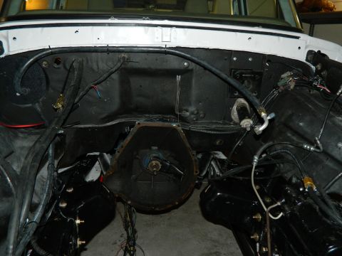 1979 Ford Bronco - The engine bay of a vehicle is shown with the transmission housing and various hoses and wiring.