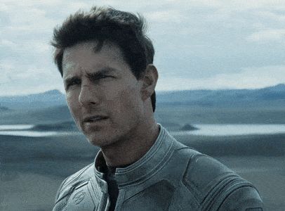 2000 Mercury Grand Marquis - A man in a grey jumpsuit stands in a desert landscape with mountains in the background.