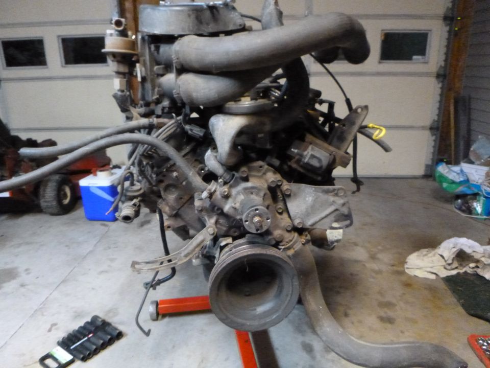 Disassembled engine on an engine stand in a garage.