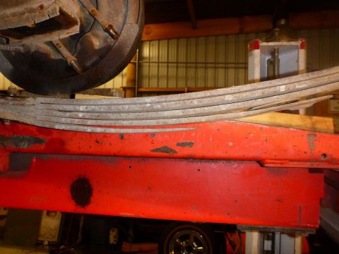 1964 Mercury Monterey - A close-up view of a vehicle's suspension system, focusing on a red component and a tire.