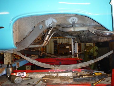 1964 Mercury Monterey - Close-up view of the rear suspension components, including leaf springs and exhaust pipes, on a blue vehicle.