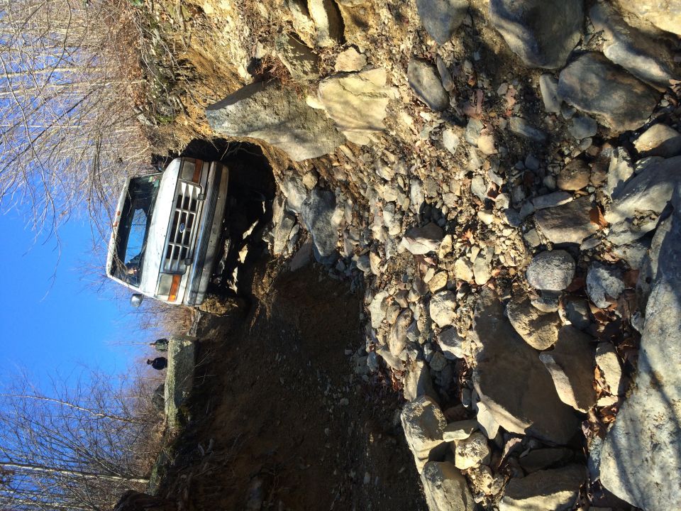 White 1994 Ford Bronco on a steep, rocky off-road trail.