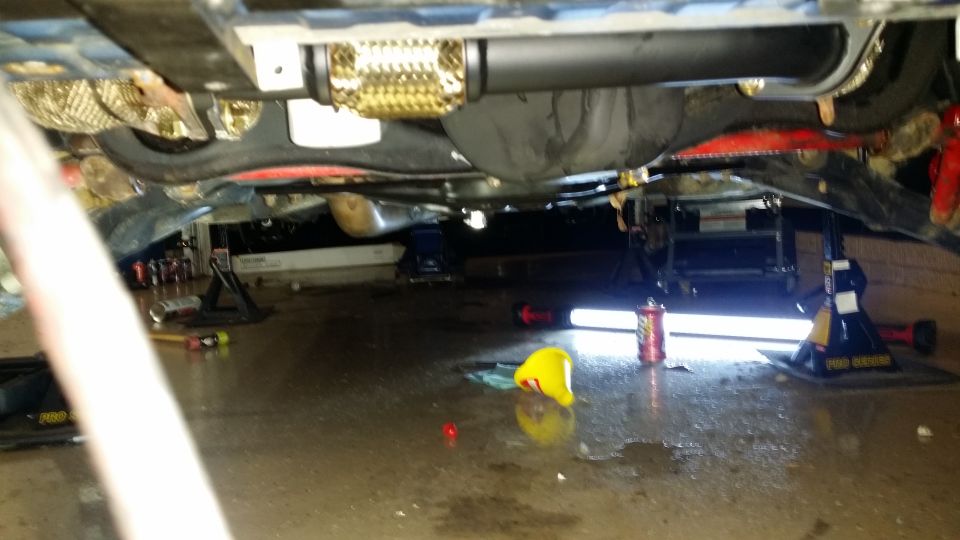 Underside of a Subaru Impreza on jack stands, showing exhaust and suspension.