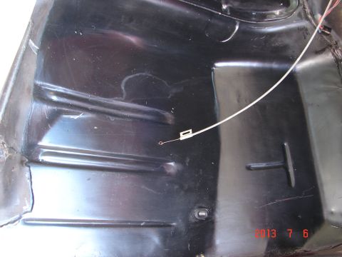 1979 Ford F-150 - A close-up view of the underside of a black vehicle, possibly a truck bed or undercarriage, showing ribbed metal panels and a white wire wi…