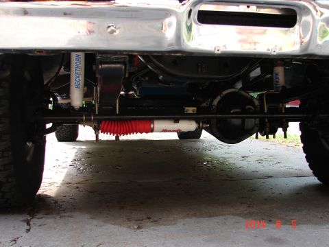 1979 Ford F-150 - Underside view of a Ford F-150 pickup truck, showing the front suspension components including shocks, springs, and steering linkage. A red…