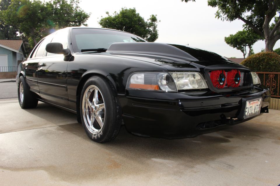 Black Mercury Marauder front quarter view with chrome wheels and red headlights