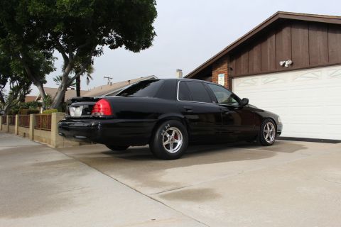 2003 Ford Crown Victoria - Rear three-quarter photo of a black Ford Crown Victoria parked next to a garage.