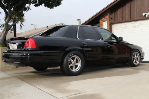 2003 Ford Crown Victoria - Rear three-quarter photo of a lowered black Ford Crown Victoria with polished five-spoke drag wheels.