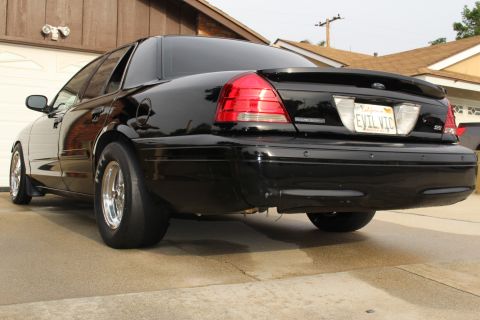 2003 Ford Crown Victoria - Rear three-quarter photo of a black Ford Crown Victoria with EVIL VIC plate in a driveway.