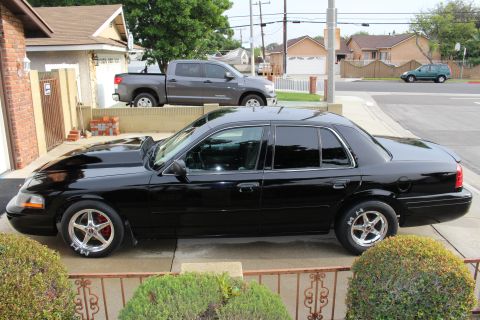 2003 Ford Crown Victoria - Side profile photo of a black Ford Crown Victoria with cowl hood and drag wheels.