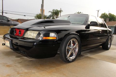 2003 Ford Crown Victoria - Front three-quarter photo of a black Ford Crown Victoria showing red cooling fans behind the grille.