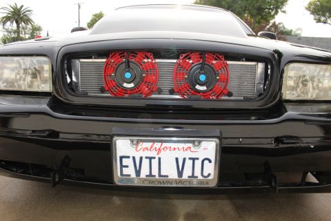 2003 Ford Crown Victoria - Close front view of a black Ford Crown Victoria grille with intercooler and twin red fans, EVIL VIC plate.