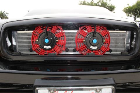2003 Ford Crown Victoria - Close-up photo of the front-mount intercooler and twin red cooling fans behind a Crown Victoria grille.
