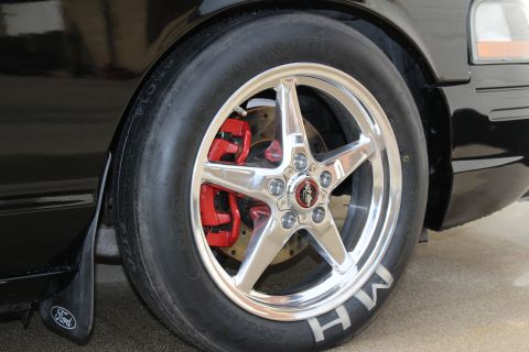 2003 Ford Crown Victoria - Close-up photo of a polished drag wheel, red caliper, and M/H tire with a Ford mud flap.