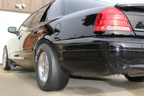 2003 Ford Crown Victoria - Photograph of a black sedan from the rear three-quarter angle showing drag slicks and polished wheels, not a technical document.