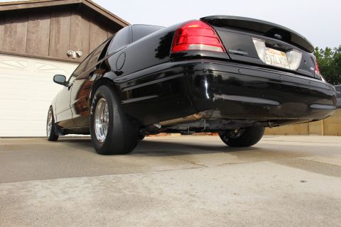 2003 Ford Crown Victoria - Photograph of the rear underside of a black sedan with drag slicks and exhaust, not a technical document.