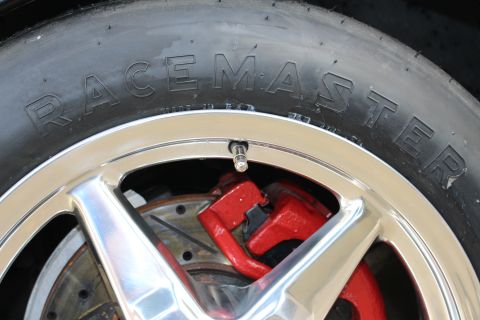 2003 Ford Crown Victoria - Photograph close-up of a Racemaster drag tire sidewall, wheel, and red caliper, not a technical document.
