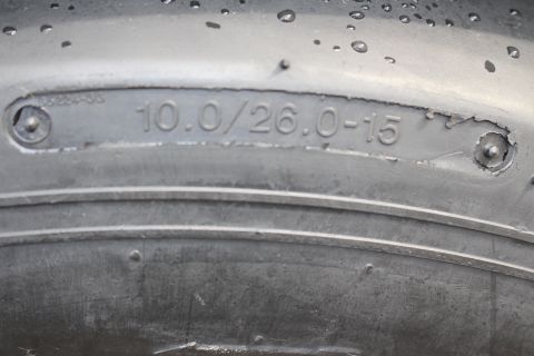 2003 Ford Crown Victoria - Photograph of a drag tire sidewall with molded size marking 10.0/26.0-15, not a technical document.