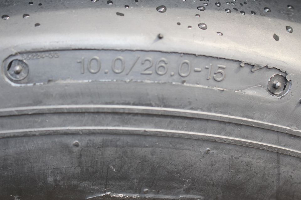 Close-up of a drag tire sidewall showing molded size 10.0/26.0-15
