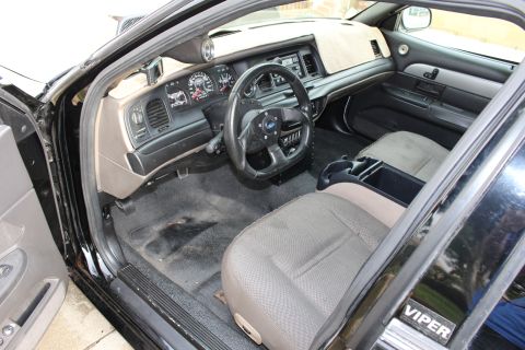 2003 Ford Crown Victoria - Photograph of the interior of a black sedan showing the dash and steering wheel, not a technical document.