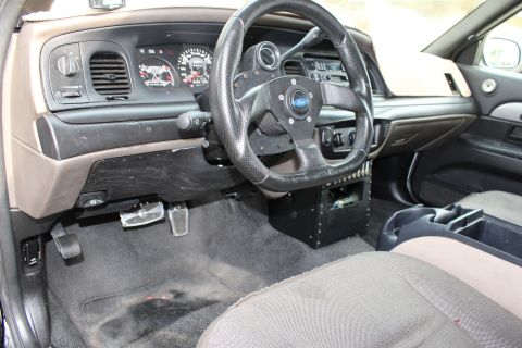 2003 Ford Crown Victoria - Photograph of a modified sedan interior with custom steering wheel and center panel, not a technical document.