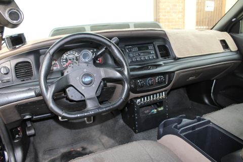 2003 Ford Crown Victoria - Photograph of a modified sedan interior with dashboard and custom switch panel, not a technical document.