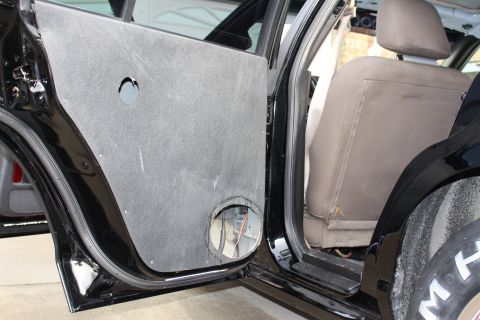 2003 Ford Crown Victoria - Photograph of a black sedan's open rear door with a custom panel and rear seat, not a technical document.
