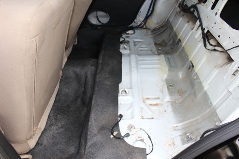 2003 Ford Crown Victoria - Photo of a sedan's rear floor pan during a restoration with the carpet pulled back exposing bare metal.