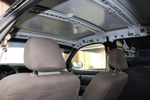 2003 Ford Crown Victoria - Photo of a sedan interior showing the exposed roof structure, seats, and headliner area.