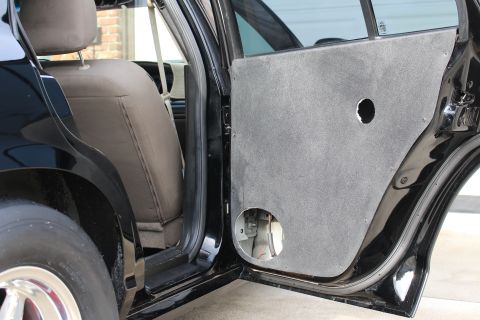 2003 Ford Crown Victoria - Photo of a black sedan's open rear door with the trim panel removed exposing speaker holes.