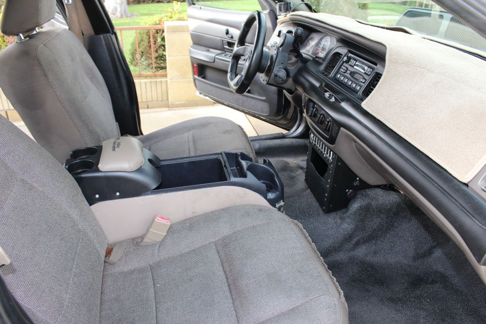Front cabin of a car with gray cloth seats, center console and dashboard