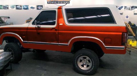 1982 Ford Bronco - This 1980s Ford Bronco is shown from the side in an orange and white two-tone paint scheme.
