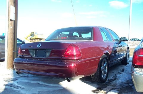 2001 Ford Crown Victoria - Rear view of a red 2001 Ford Crown Victoria parked outdoors in snowy conditions.