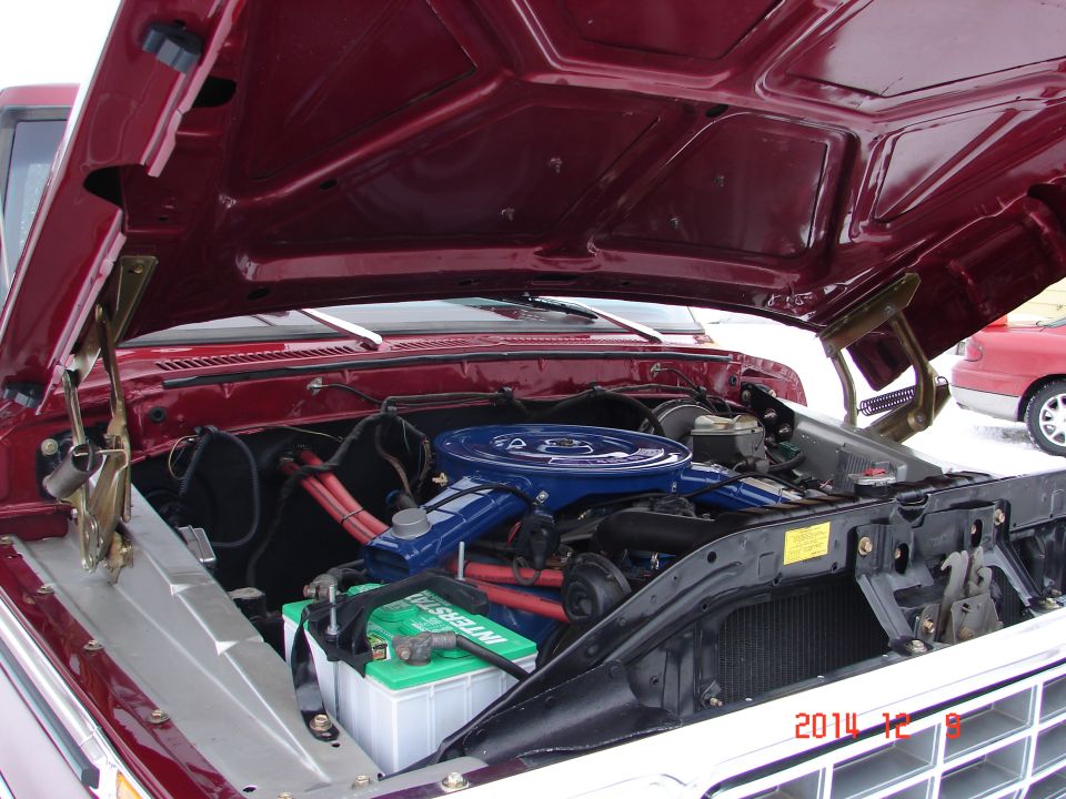 1979 Ford F-150 engine bay with blue air cleaner and red spark plug wires.