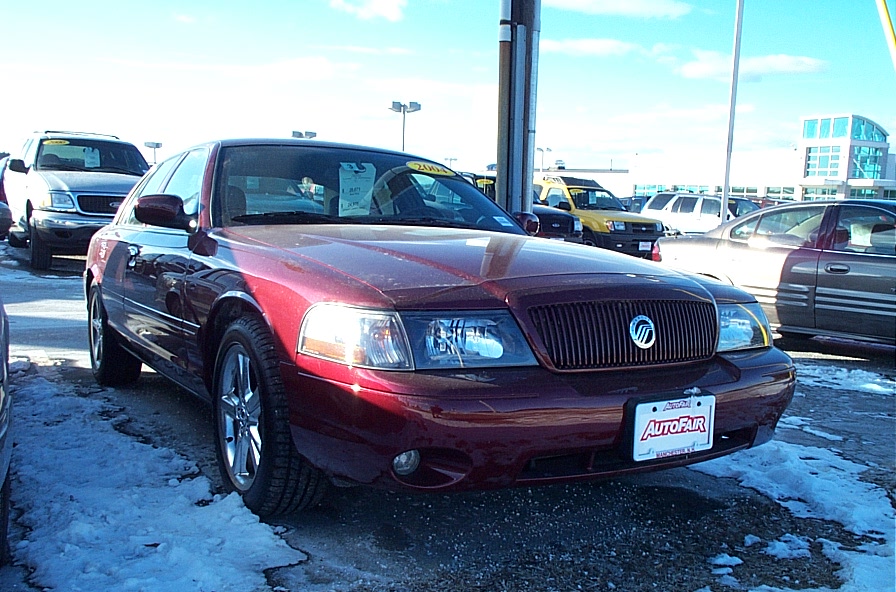 Red sedan with vertical grille and chrome wheels