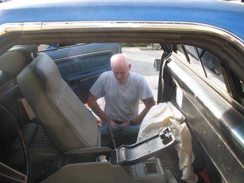 1972 Ford Ranchero - A person enters the interior of a vehicle through the open passenger door.