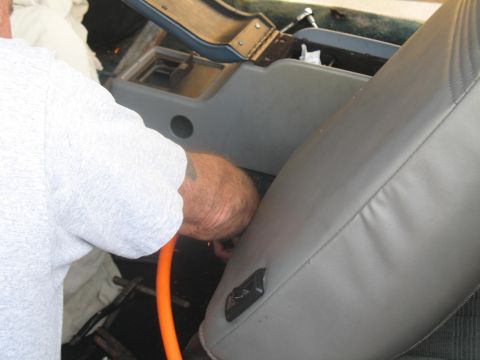 1972 Ford Ranchero - A close-up interior shot of a vehicle, showing gray upholstery and a person.
