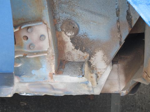 1972 Ford Ranchero - Close-up view of rusted metal frame and body panel with peeling blue paint.