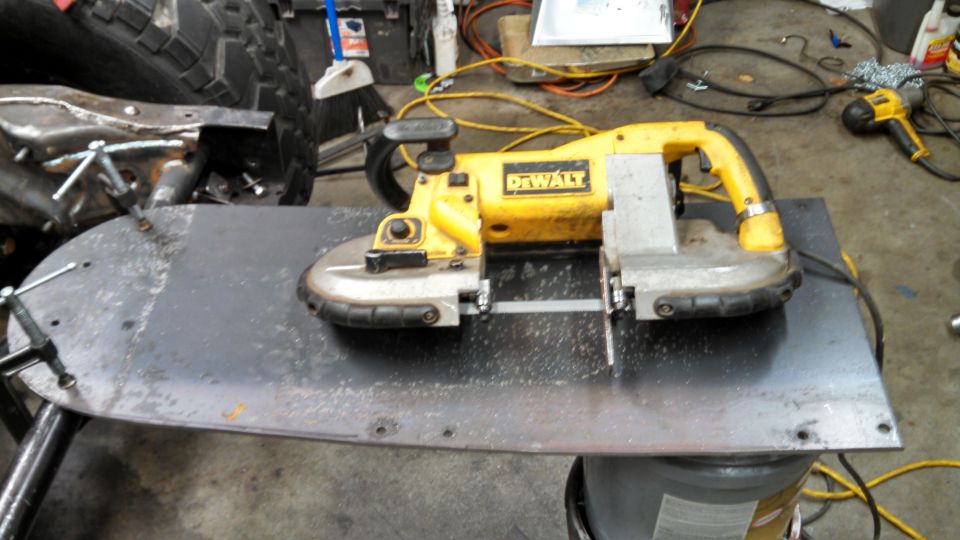 Yellow and silver DeWalt band saw on a metal surface with metal shavings.