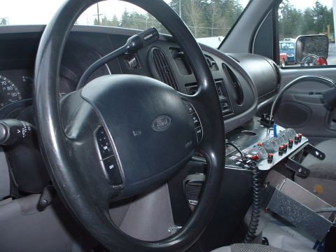 1999 Ford Crown Victoria - Interior view of a van, showing the steering wheel, dashboard, and a custom control panel.