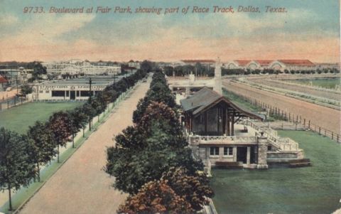1909 Ford Model T - A street scene at Fair Park in Dallas, Texas, showing a road lined with trees leading towards buildings and a racetrack.