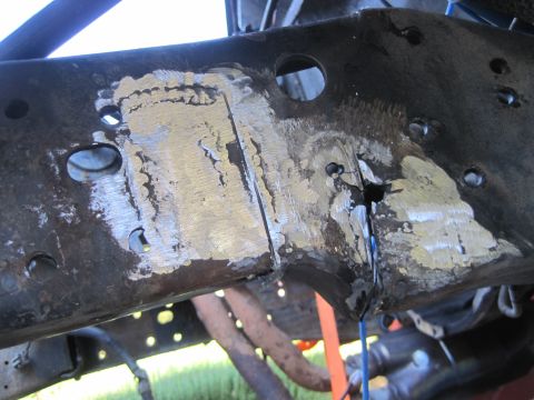 1989 Ford Bronco - Close-up of a damaged vehicle frame section, indicating repair work and structural compromise.