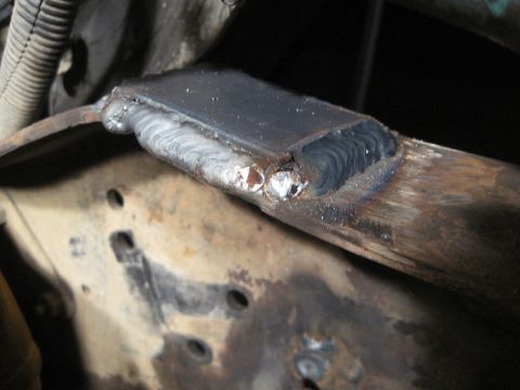 1989 Ford Bronco - Close-up of a welded metal part on a vehicle frame, showing signs of repair and rust.