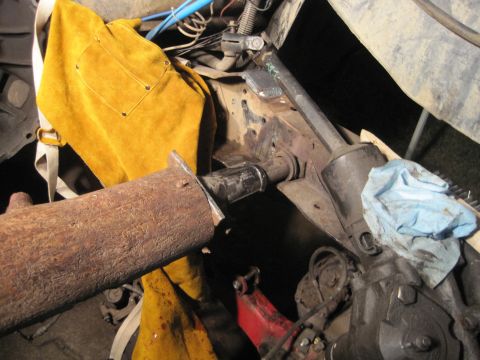 1989 Ford Bronco - Vehicle frame and suspension components are visible, along with a welding apron and a blue cloth.